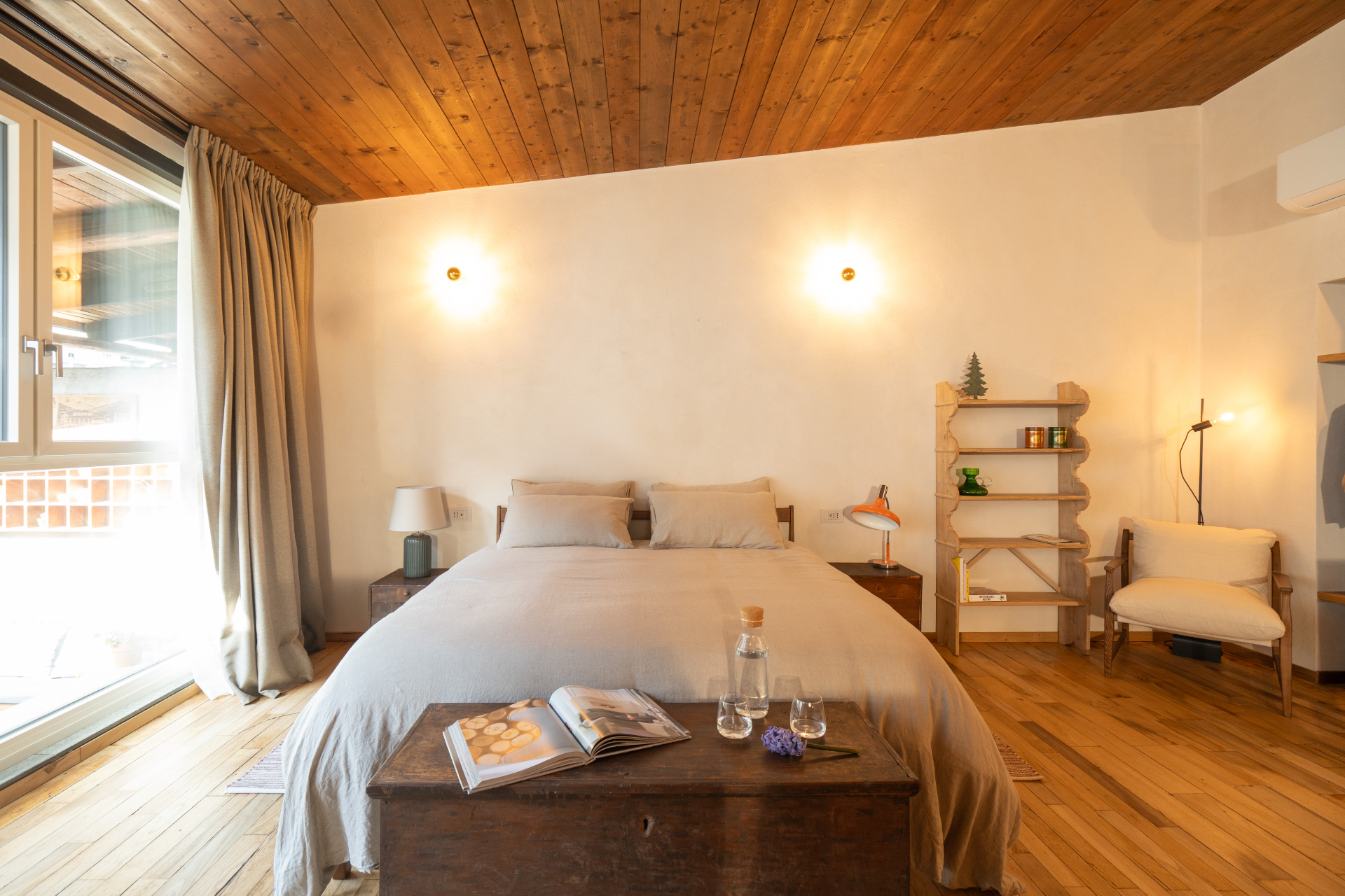 The bedroom of La DolceVilla with a double bed and wooden ceiling